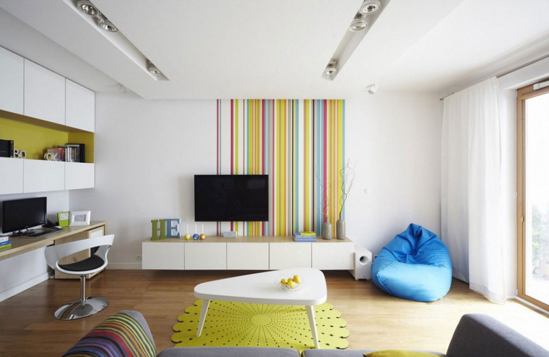 Wallpaper with vertical stripes in the interior of the living room with white walls.