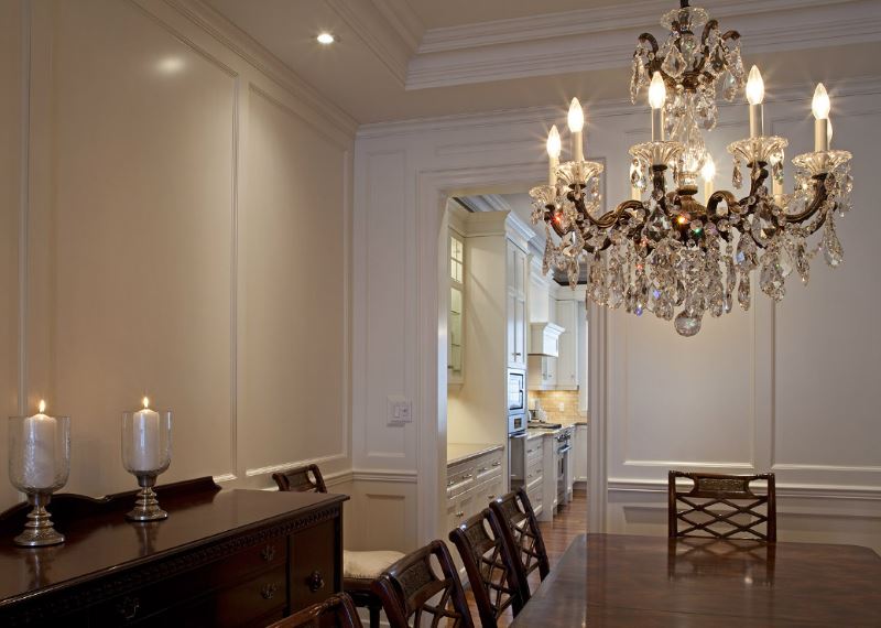 Crystal chandelier in the design of the living room with white walls in a classic style