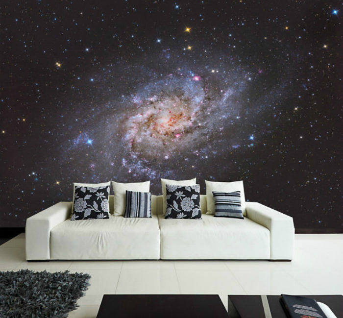 White sofa on the background of space wallpaper