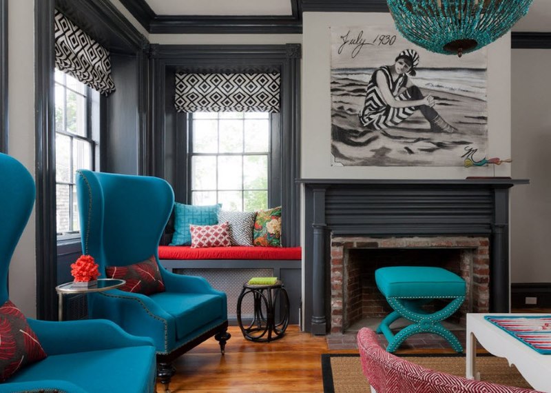 Chairs with turquoise upholstery and a narrow strip of red pillows on the sofa