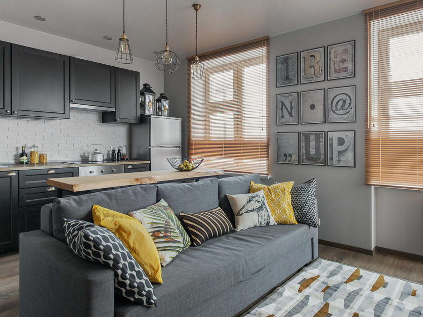 Divano grigio in cucina-soggiorno in colori pastello