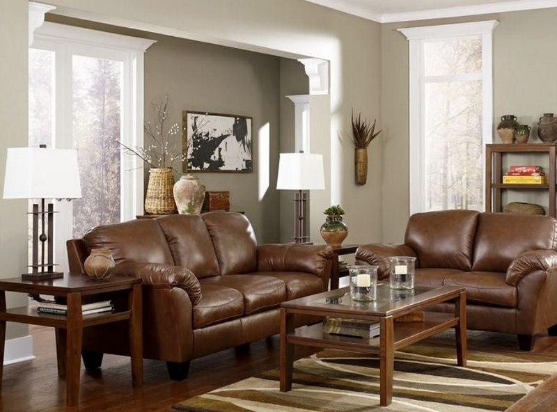 Canapé en faux cuir marron contre les murs gris clairs du salon