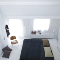 Black bed in a white bedroom
