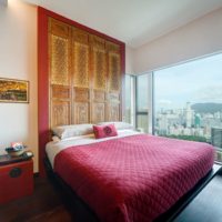 Couvre-lit rouge dans un lit dans la chambre d'un immeuble à plusieurs étages