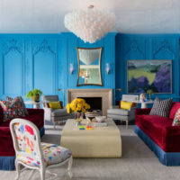 Salon aux murs bleus et un canapé bordeaux