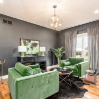 Living room with gray walls and a green sofa.
