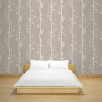 Wooden bed on a background of wallpaper with a floral print