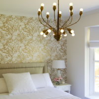 Bijeli tekstilni krevet i luster s otvorenom svjetiljkom