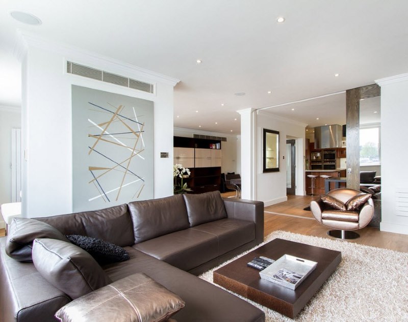 Interno di un luminoso soggiorno minimalista con un divano marrone