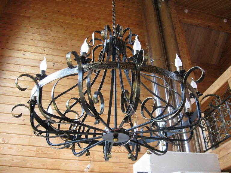 Forged chandelier on the background of wooden trim living room