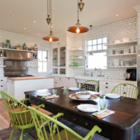 Chaises vertes dans une cuisine-salon blanche