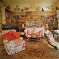 Living room library with bright armchairs
