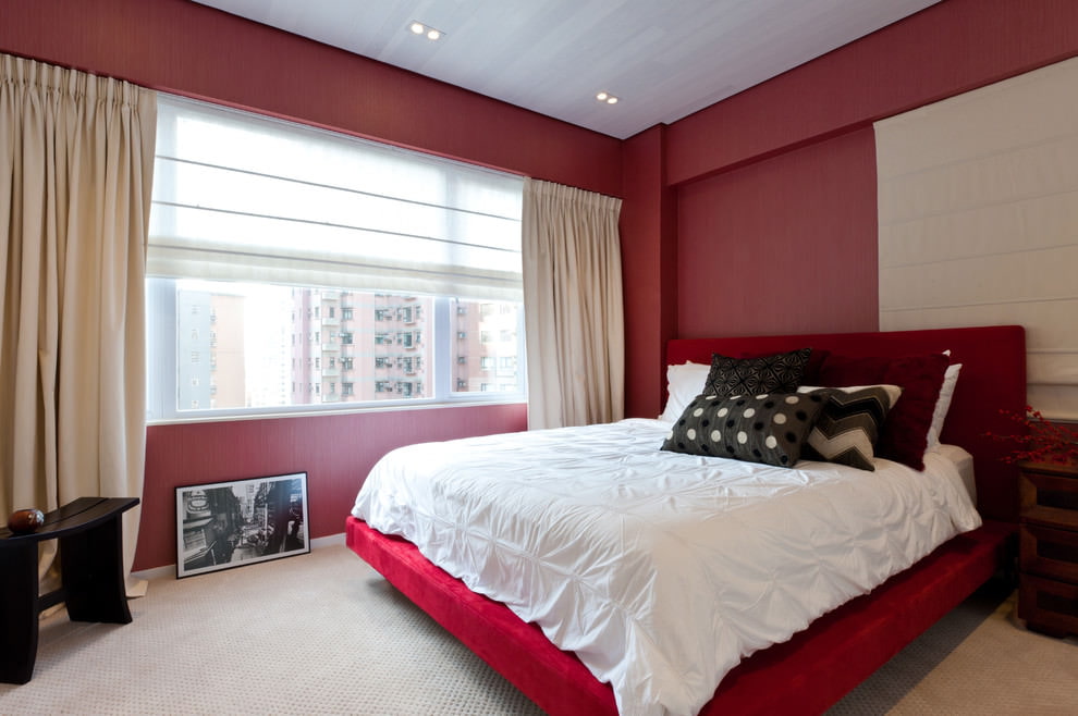 Interno camera da letto minimalista con pareti rosse.