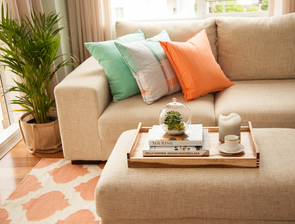 Orange pillow on a sofa with burlap upholstery