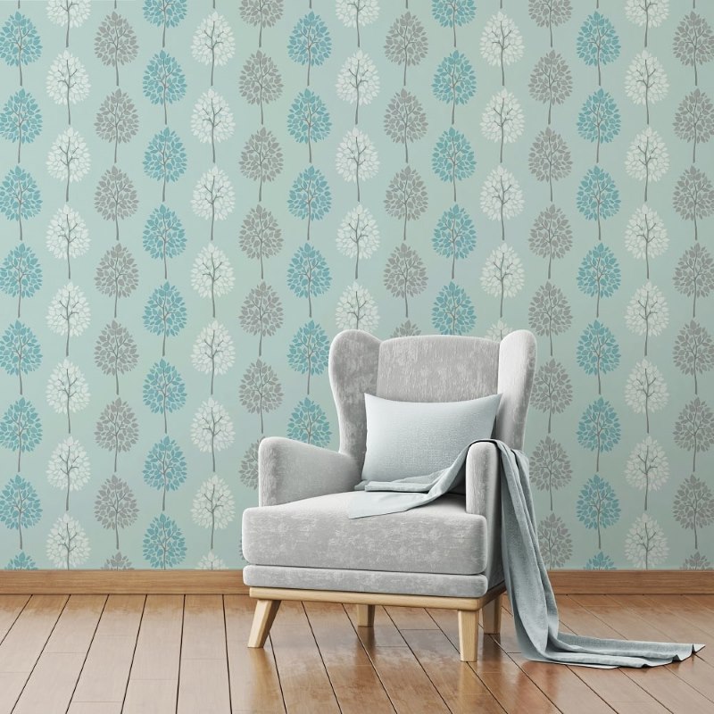 Soft vintage armchair on the background of a wall decorated with wallpaper with natural ornaments