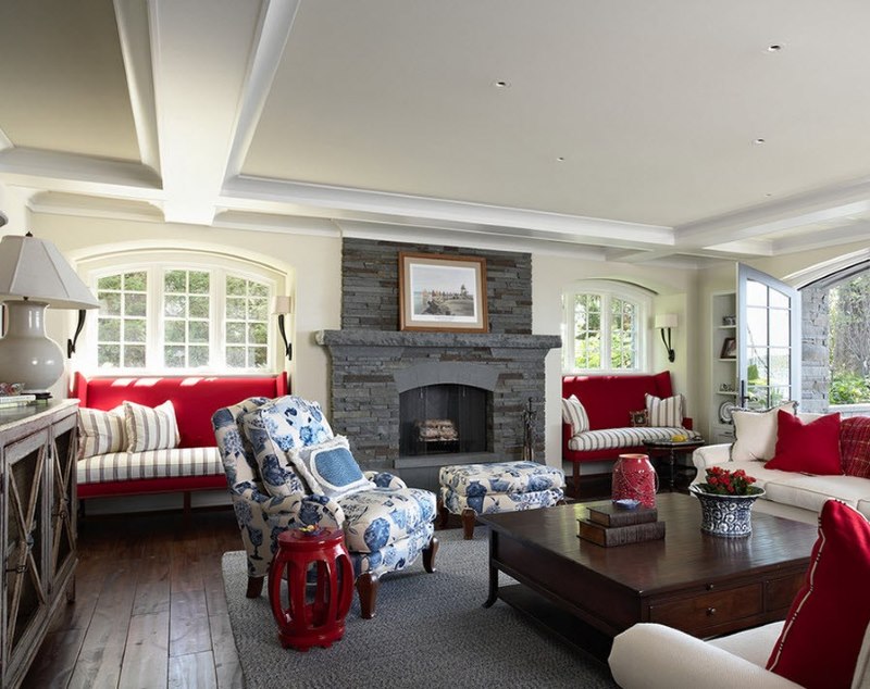 La combinazione di sfumature rosse, bianche e blu all'interno del soggiorno con un camino grigio