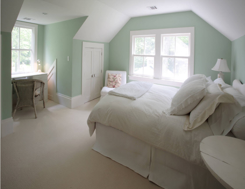 Letto bianco e pareti di menta nella camera da letto di una casa privata