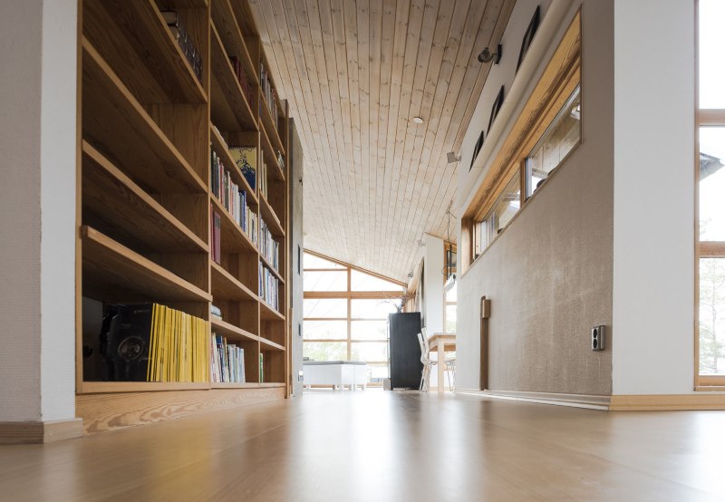 Bibliothèques en bois naturel dans le couloir d'une maison privée