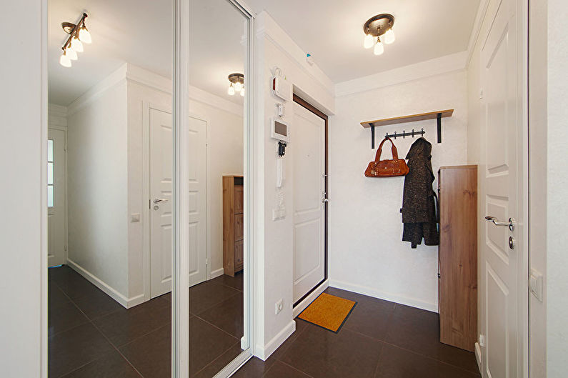 Armoire à portes coulissantes avec portes en miroir dans un couloir compact