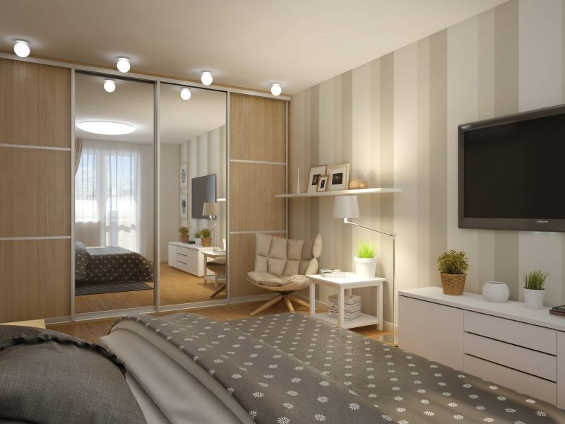 Wardrobe with sliding mirrors in a bedroom studio apartment