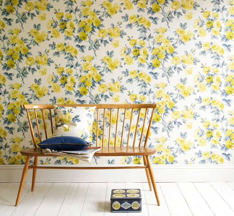 Wallpaper with yellow flowers on the wall of the living room of a country house