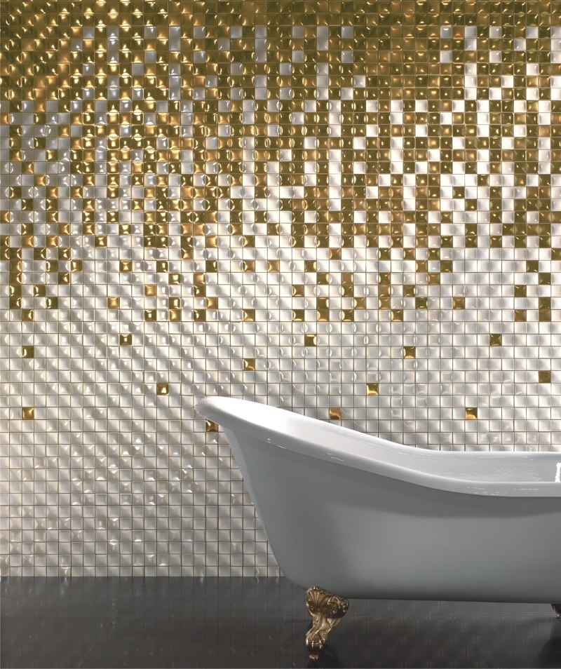 White bath on a background of a wall with golden mosaic