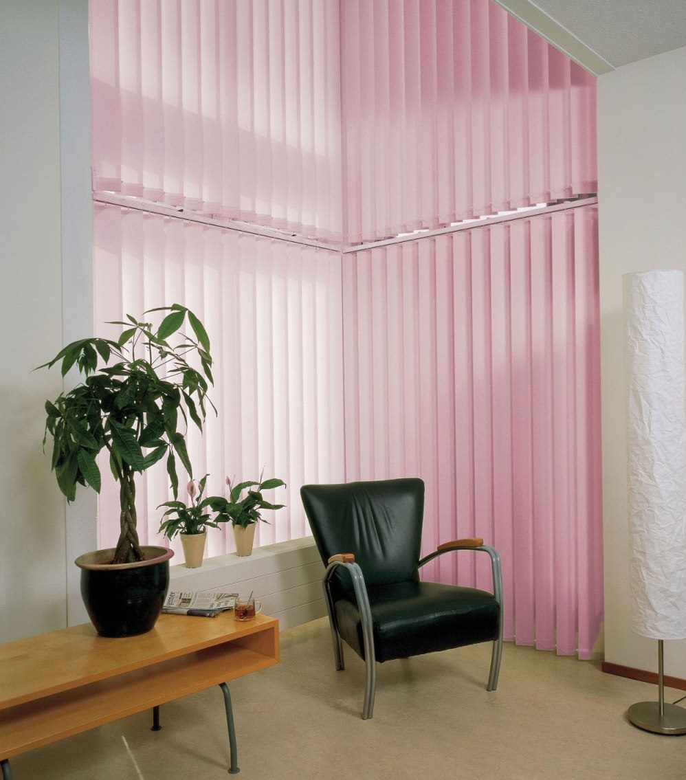 Black armchair on the background of light pink blinds