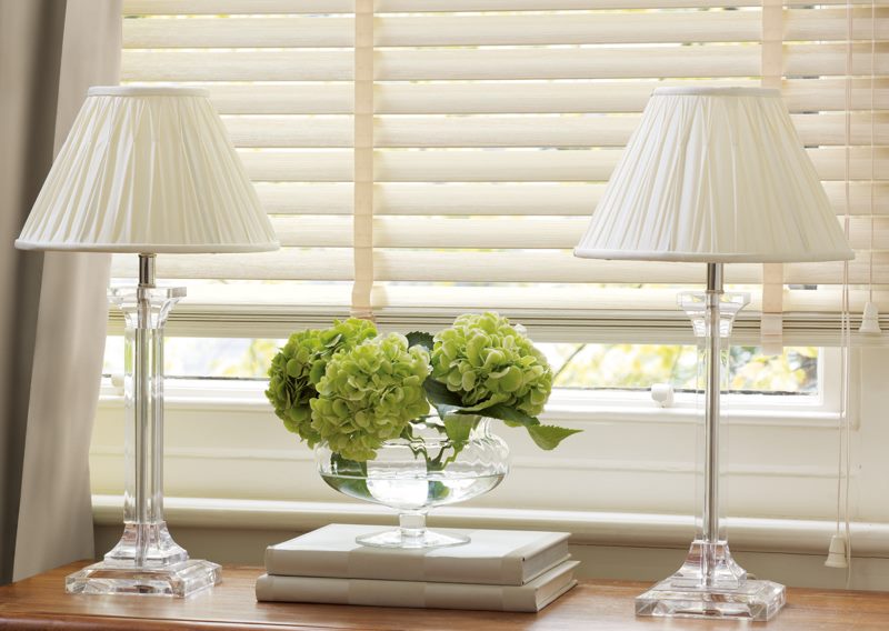 Two table lamps next to the plastic blinds