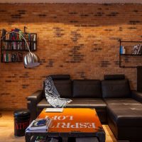 Black sofa on red brick wall background