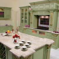 Green kitchen with island for cooking