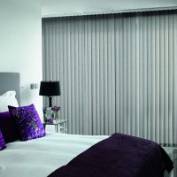 Bedroom with closed vertical blinds