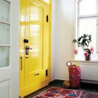 Colorful carpet in front of the yellow door in the hallway