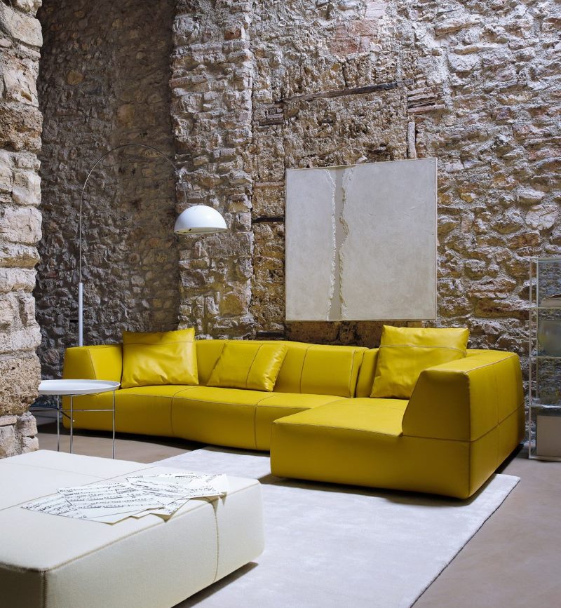 Mustard sofa in an industrial style living room interior