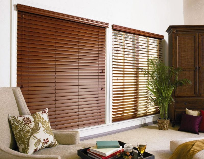 Two windows in the living room with wooden shutters