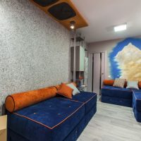 Miesto buto gyvenamajame kambaryje yra sofos su mėlyna apmušalais
