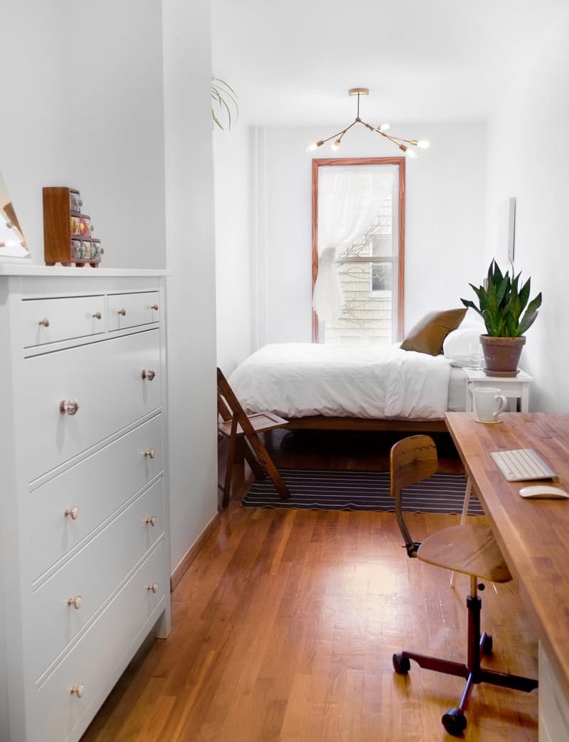 Brown table in the bedroom with white walls