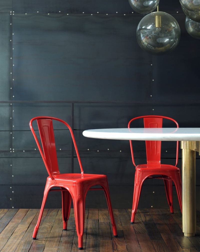 Two red chairs against a black wall