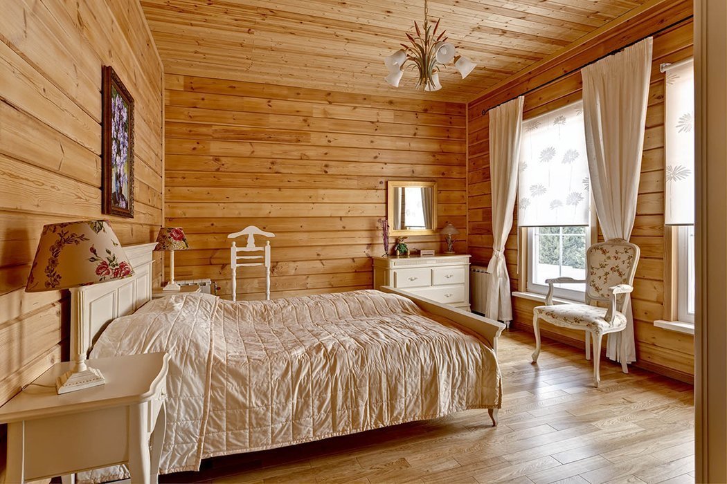 White bed in the bedroom from glued beams