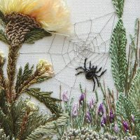 Embroidery on fabric a spider among flowers