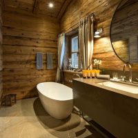 White bath in a room with wooden walls