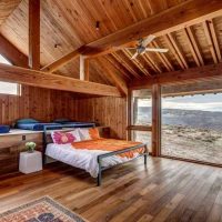 Bedroom with a panoramic window in a house made of timber