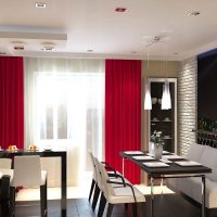The combination of red curtains with black countertops