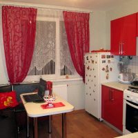 Red curtains in the interior of a small kitchen