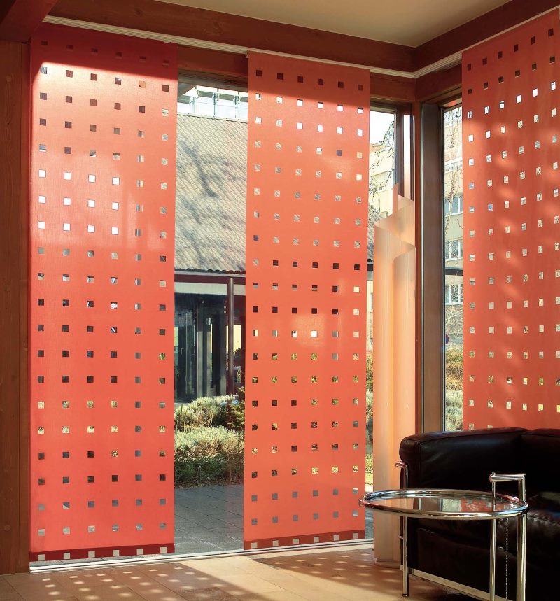 Red Japanese perforated curtains on a large living room window