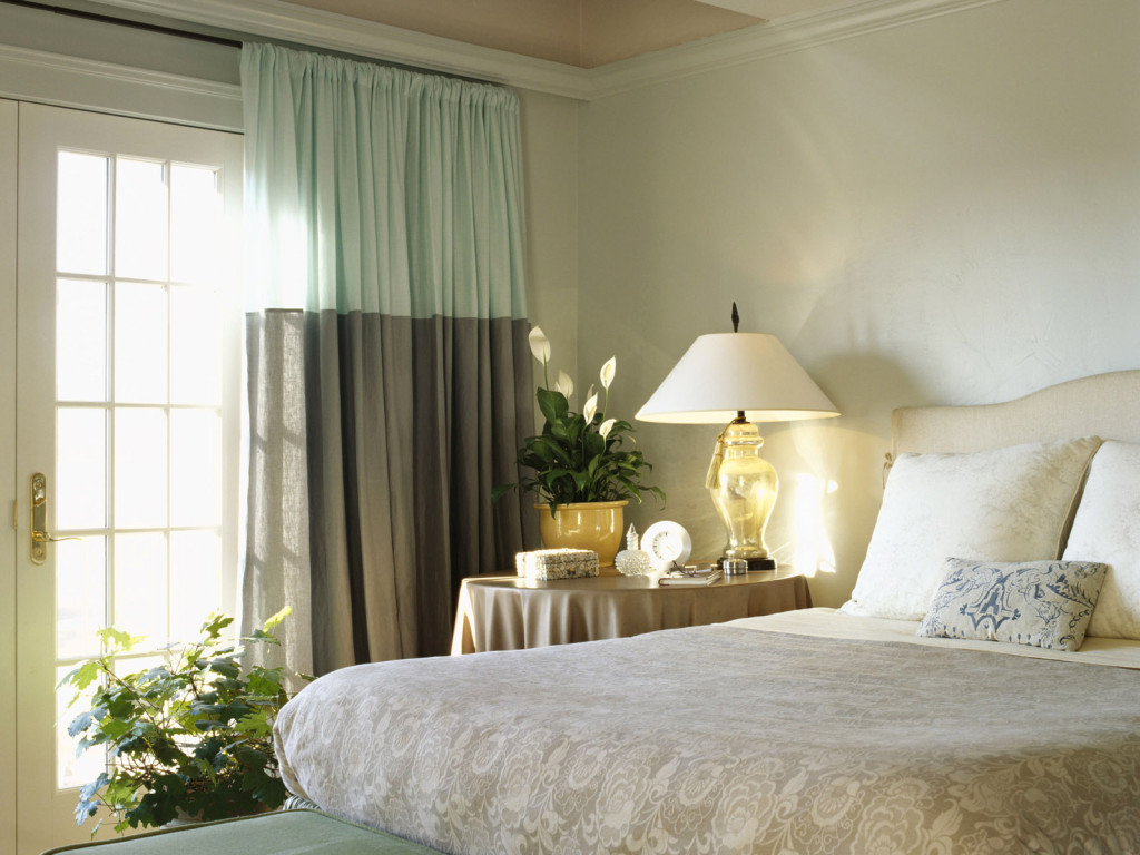 Two-tone curtains in the bedroom with a lamp on the bedside table