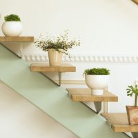 Shelves for indoor plants on the railing of the stairs