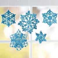 Decorating a window with paper snowflakes