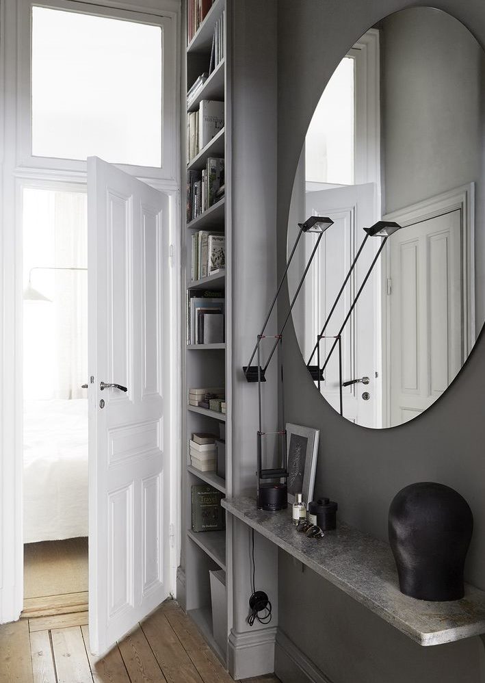 Oval mirror on the gray wall of the hallway