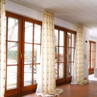 Panoramic windows of the living room with wooden frames