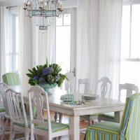 White tulle curtains on the windows of a bright kitchen